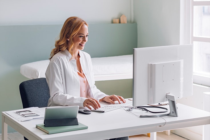 Doctor in lab coat at computer