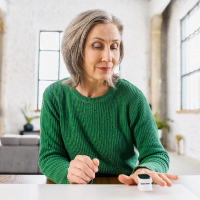 Woman taking blood oxygen reading with pulse oximeter