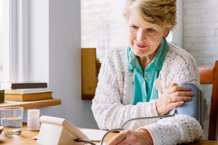 Woman In Sweater Taking Her Blood Pressure Readings